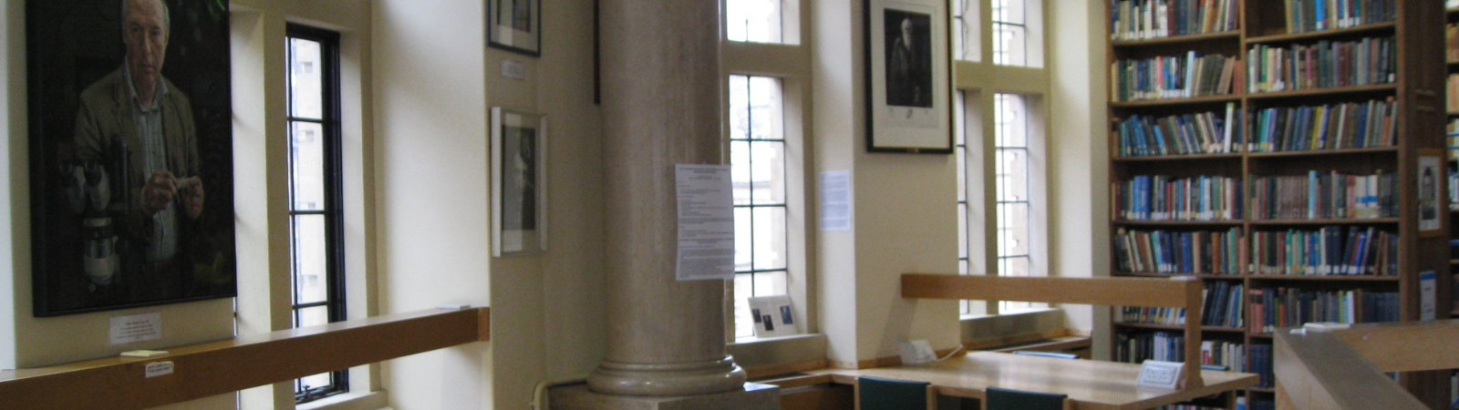 A shot of the Zoology Library showing desks, some art on the walls and tall bookcases. 